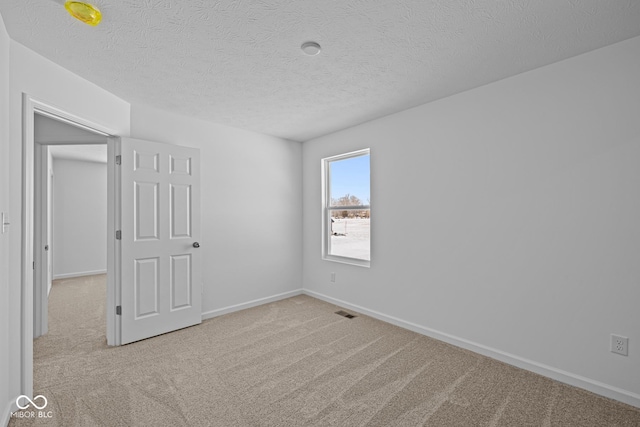 unfurnished bedroom with carpet flooring, visible vents, baseboards, and a textured ceiling