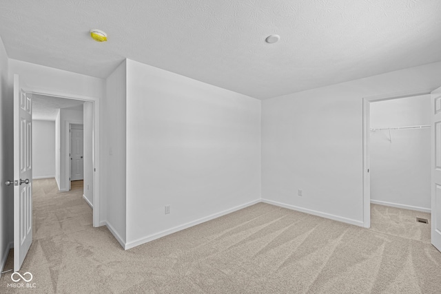 spare room with light carpet and a textured ceiling