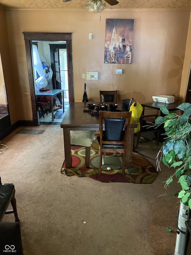 carpeted dining space with ceiling fan