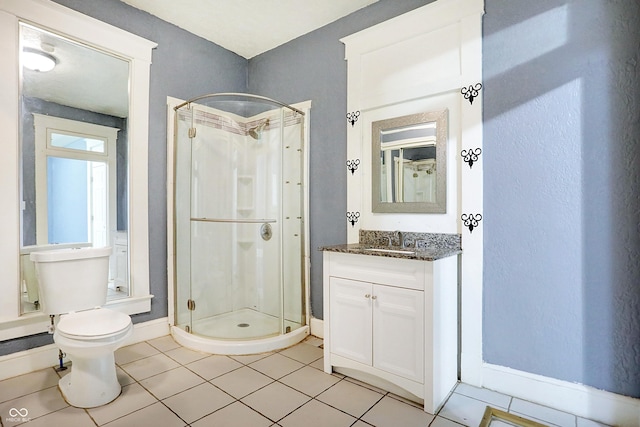 bathroom featuring tile patterned floors, vanity, toilet, and walk in shower