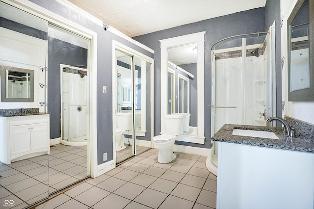 bathroom with tile patterned floors, a shower, vanity, and toilet