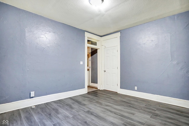 empty room featuring hardwood / wood-style flooring and a textured ceiling