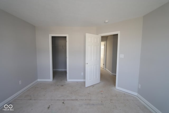 unfurnished bedroom featuring a walk in closet and a closet