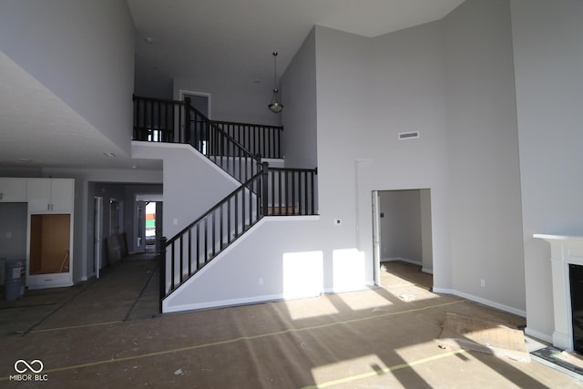 unfurnished living room featuring a high ceiling