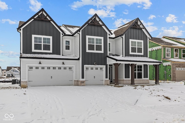 view of front of property featuring a garage, brick siding, and board and batten siding