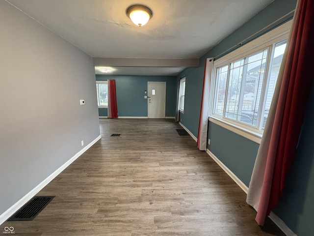 corridor featuring a wealth of natural light and hardwood / wood-style flooring