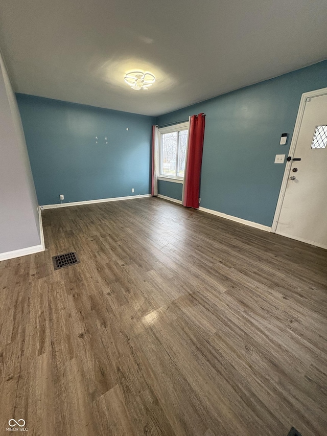 unfurnished room with dark wood-type flooring