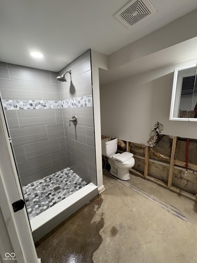 bathroom with toilet, a shower, and concrete floors