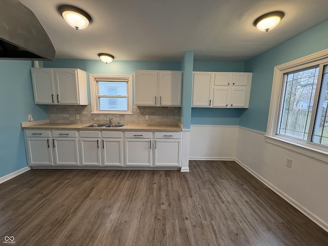 3919 E 34th St, Indianapolis, IN 46218 - kitchen featuring exhaust hood, white cabinets, backsplash, dark wood-type flooring, and light countertops
