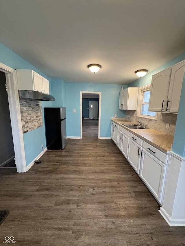 kitchen featuring sink, dark hardwood / wood-style flooring, stainless steel fridge, decorative backsplash, and white cabinets