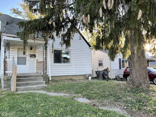 3919 E 34th St, Indianapolis, IN 46218 - view of property hidden behind natural elements featuring a front yard and a shingled roof