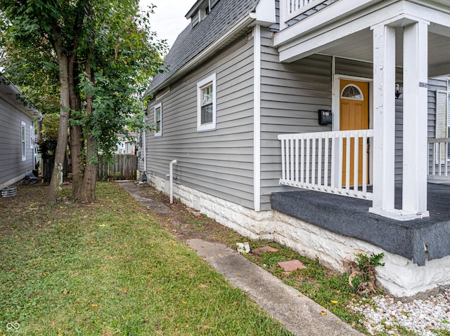 view of home's exterior with a lawn and a porch