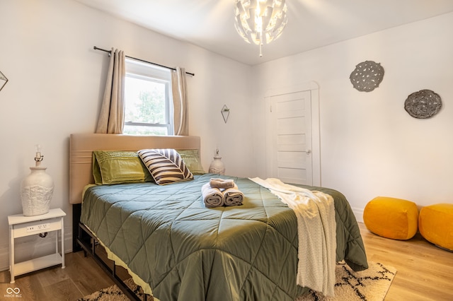 bedroom with a chandelier and wood-type flooring