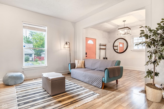 living room with wood-type flooring and an inviting chandelier