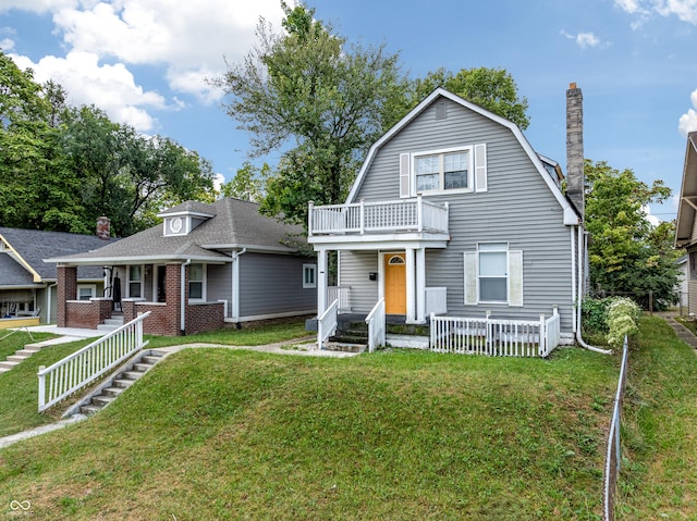 view of front of house with a front yard and a balcony