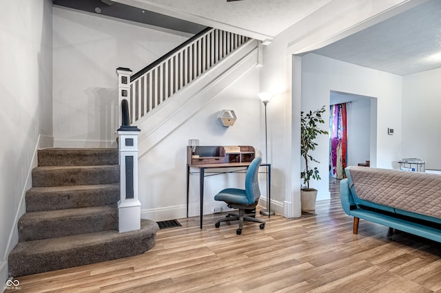 bedroom with a textured ceiling and light hardwood / wood-style floors