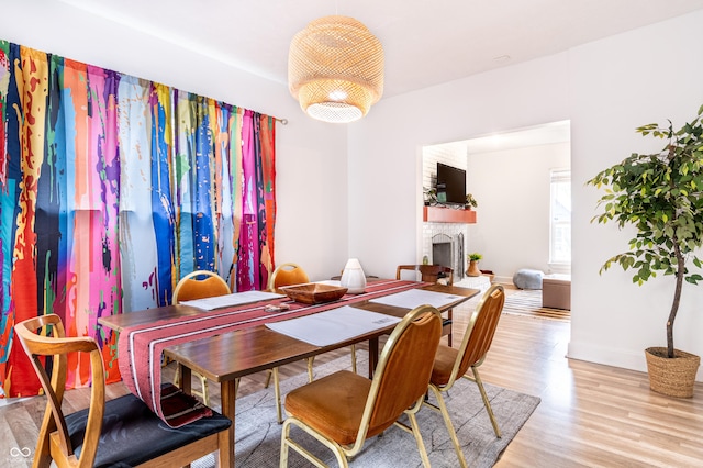 dining area featuring a fireplace and light hardwood / wood-style flooring