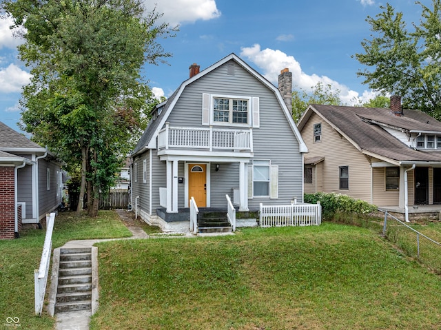 view of front of house featuring a front yard and a balcony