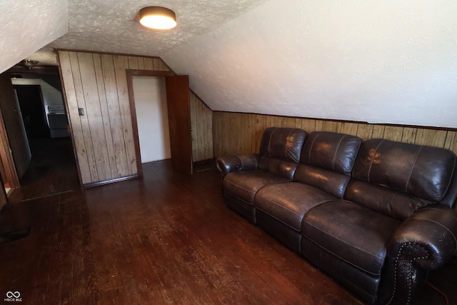 living room featuring a textured ceiling, dark hardwood / wood-style flooring, lofted ceiling, and wooden walls