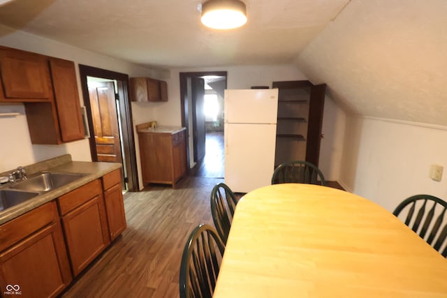 kitchen featuring dark hardwood / wood-style floors, white refrigerator, sink, and vaulted ceiling