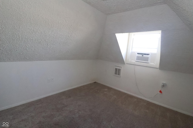 bonus room featuring lofted ceiling, cooling unit, dark carpet, and a textured ceiling