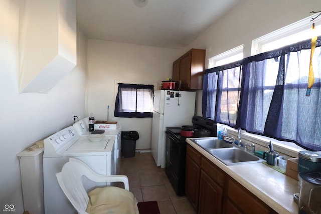 kitchen featuring sink, light tile patterned floors, white refrigerator, separate washer and dryer, and black electric range oven