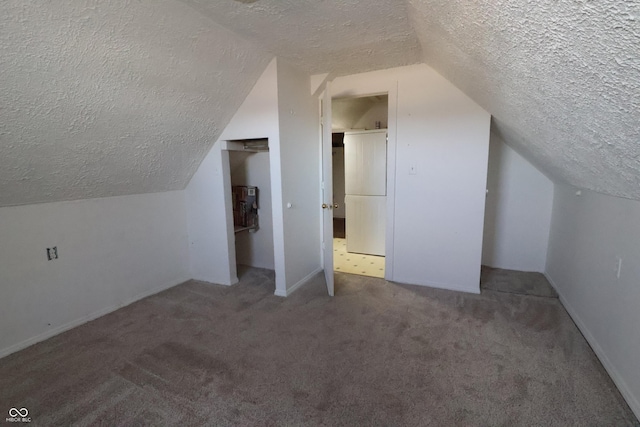 bonus room with a textured ceiling, carpet floors, and lofted ceiling