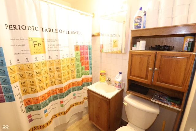 bathroom with vanity, curtained shower, toilet, and tile walls