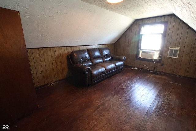 additional living space featuring cooling unit, wooden walls, vaulted ceiling, a textured ceiling, and dark hardwood / wood-style flooring