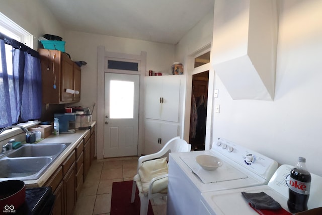 kitchen with washer and dryer, light tile patterned floors, and sink