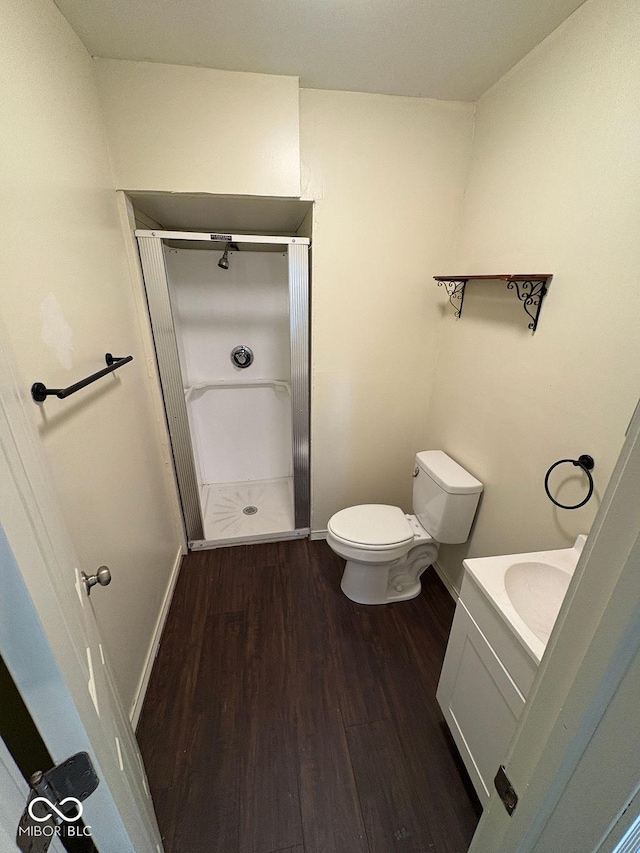 bathroom with toilet, a shower, vanity, and hardwood / wood-style flooring