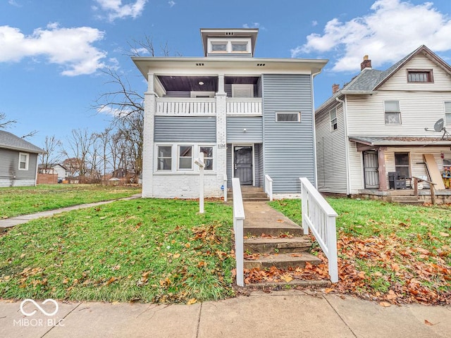 view of front of home featuring a balcony and a front yard