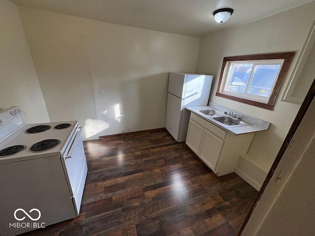 kitchen with white appliances, white cabinets, dark hardwood / wood-style flooring, and sink