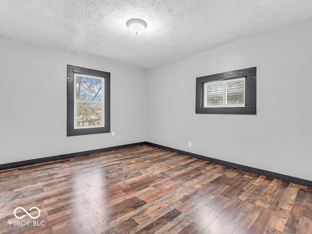 unfurnished room featuring a textured ceiling and dark hardwood / wood-style floors