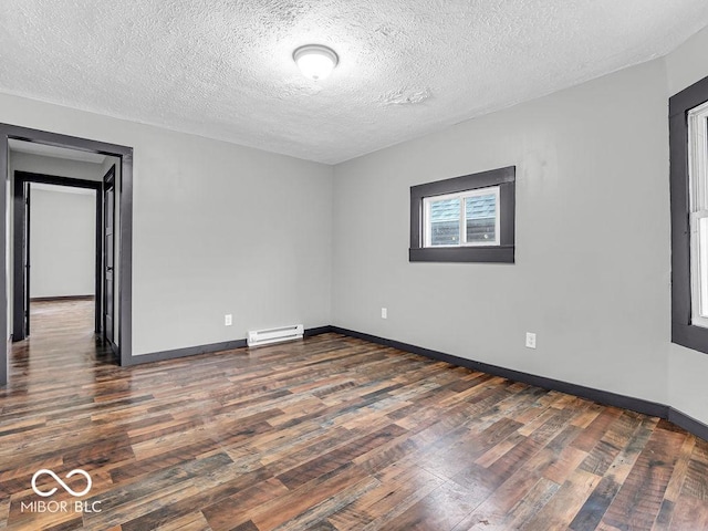 spare room featuring a textured ceiling, dark wood-type flooring, and a baseboard radiator