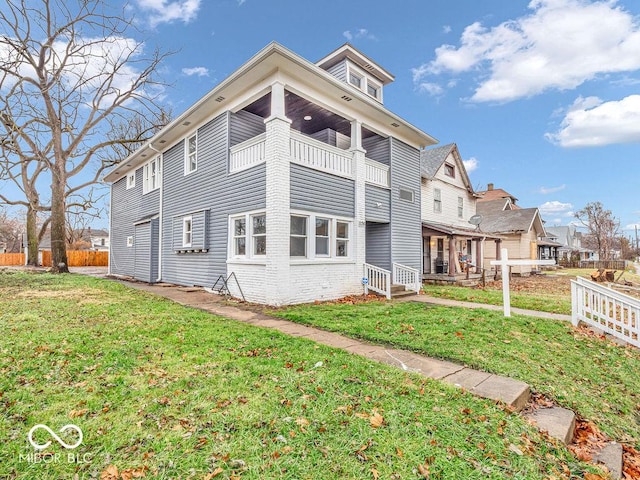 view of side of home with a balcony and a lawn