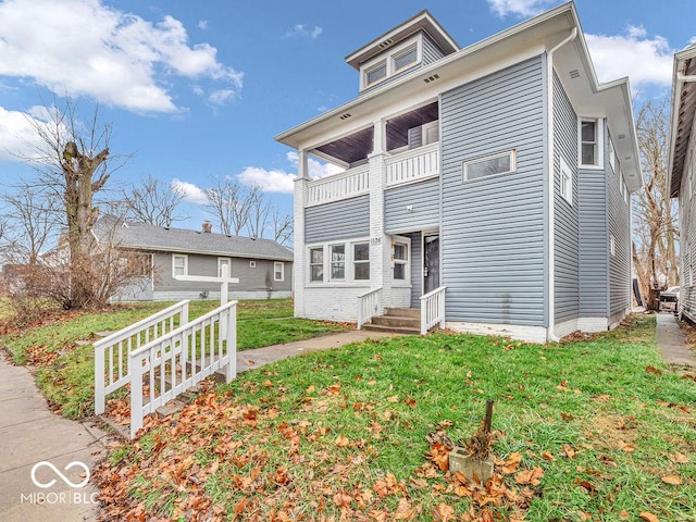 view of front of home featuring a front yard and a balcony