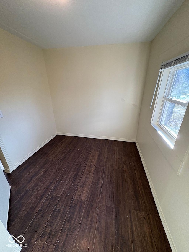 unfurnished room with dark wood-type flooring