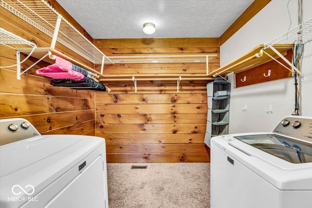 laundry room with carpet flooring, a textured ceiling, and separate washer and dryer