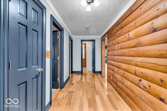 hallway featuring light hardwood / wood-style floors and a textured ceiling