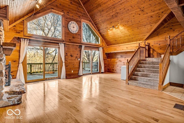 unfurnished living room featuring light wood-type flooring, wooden ceiling, and a healthy amount of sunlight