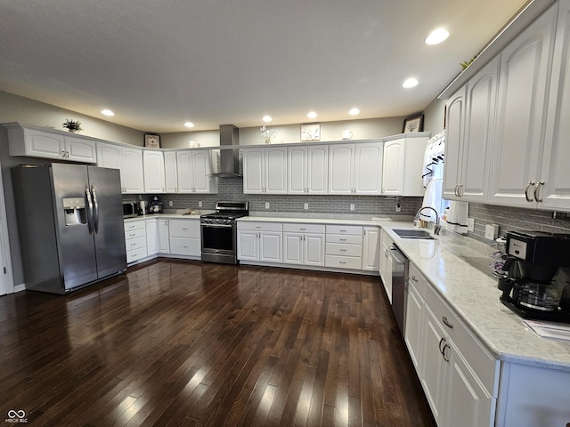 kitchen with white cabinets, dark hardwood / wood-style flooring, stainless steel appliances, and wall chimney range hood