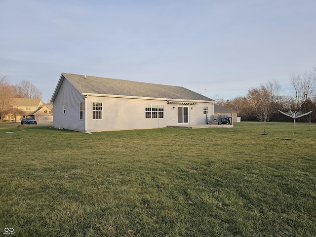 rear view of property featuring a yard and a patio area