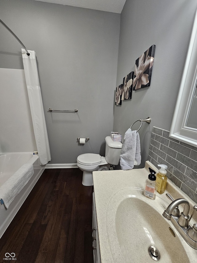 full bathroom featuring hardwood / wood-style floors, shower / bath combo, vanity, decorative backsplash, and toilet