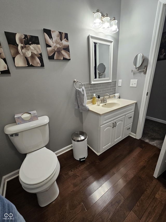 bathroom featuring decorative backsplash, toilet, vanity, and hardwood / wood-style flooring