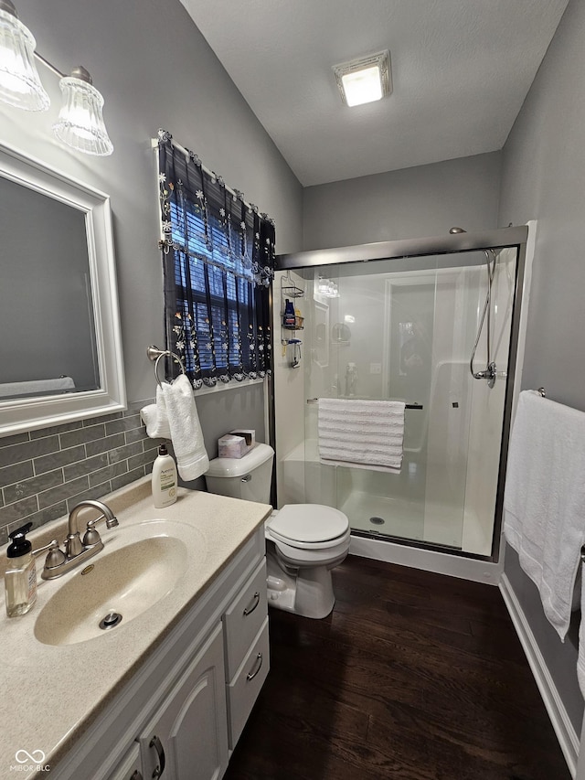 bathroom featuring vanity, wood-type flooring, backsplash, and an enclosed shower