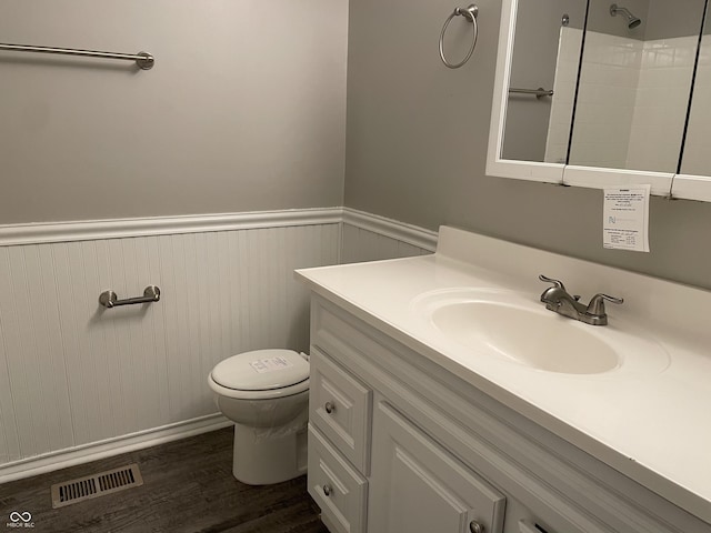 bathroom featuring a shower, hardwood / wood-style floors, vanity, and toilet