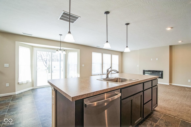 kitchen featuring dishwasher, an island with sink, a wealth of natural light, and sink