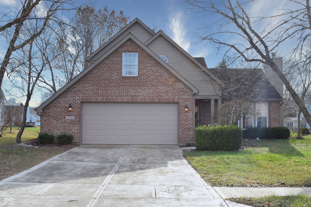 view of property featuring a garage and a front lawn