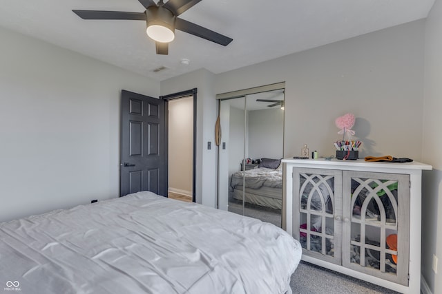 carpeted bedroom featuring ceiling fan and a closet